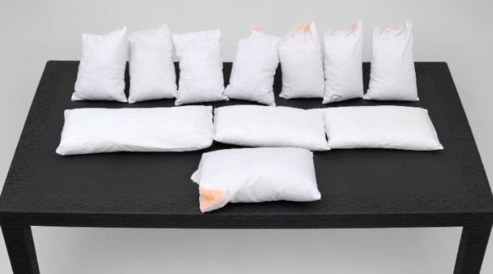 Stacked chicken feather absorbent pads